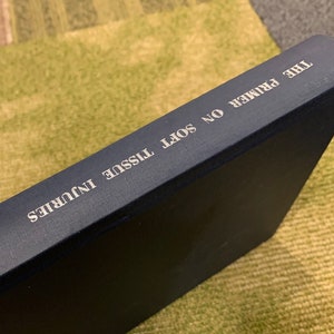 May include: A blue hardcover book titled "The Primer on Soft Tissue Injuries" by Rein, published in 1976.