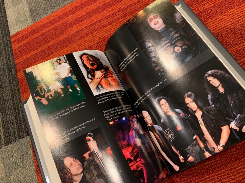 Puede incluir: Un libro abierto con fotograf&iacute;as de una banda de heavy metal. Las im&aacute;genes incluyen fotos de actuaciones en vivo y retratos de los miembros de la banda. El libro est&aacute; abierto sobre una superficie a rayas rojas y naranjas.