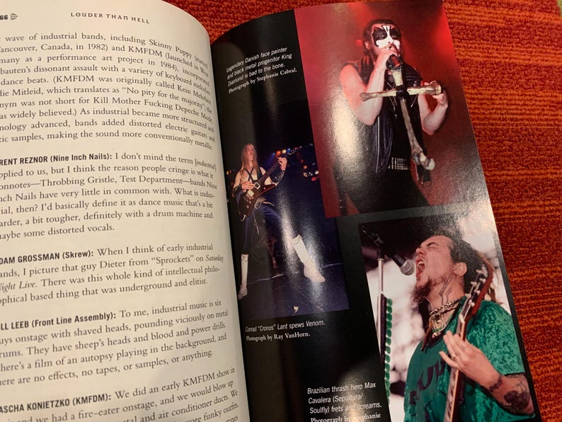 Puede incluir: Una p&aacute;gina doble de un libro titulado 'Louder Than Hell' con fotos de bandas de metal actuando. Las im&aacute;genes incluyen m&uacute;sicos con pintura facial y vestuario de escenario. El texto detalla la historia de la m&uacute;sica industrial.
