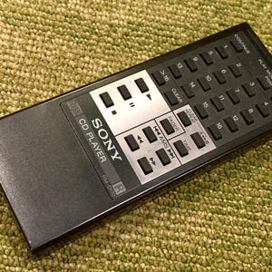 May include: A black Sony CD player remote control with numerous buttons, including number keys, play controls, and function buttons. The remote has a silver panel with the Sony logo and model number RM-0170.