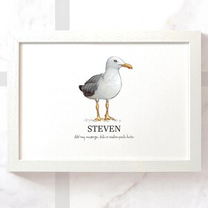 Op de afbeelding: Een wit ingelijst print met een aquarel-illustratie van een meeuw. De meeuw staat op een witte achtergrond. De naam "STEVEN" staat onder de meeuw. De tekst "Voeg een bericht, datum of aangepaste quote hier toe" staat onder de naam.