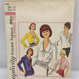 May include: Vintage Simplicity printed sewing pattern, number 5645, for women's blouses. The pattern includes illustrations of various blouse styles, with a size 12 and bust 32 measurement indicated on the cover. The cover is off-white with pink accents.