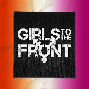 May include: A square black fabric patch featuring the white distressed text GIRLS TO THE FRONT with a central gender symbol combining male and female icons. The design has a weathered, textured appearance printed on a woven textile surface.