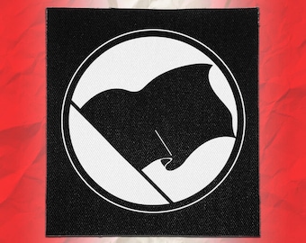 Könnte beinhalten: Ein quadratischer Stoffaufnäher mit einem schwarz-weißen Design. Die Grafik besteht aus einem soliden schwarzen Kreis, der eine stilisierte schwarze Flagge an einem diagonalen Mast zeigt, eingebettet in einen weißen Kreis mit dünnem Rand.