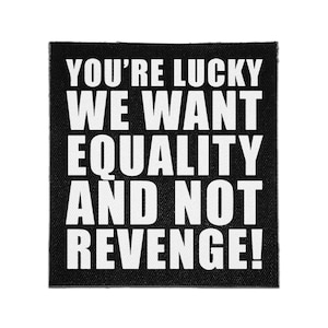 May include: A square black fabric patch featuring the white text YOU'RE LUCKY WE WANT EQUALITY AND NOT REVENGE! The design is printed in a bold, sans-serif font, covering the entire surface of the patch with a visible woven texture.