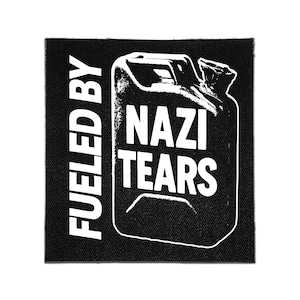 May include: A square black fabric patch featuring a white graphic of a fuel canister. The text FUELED BY is printed vertically on the left side, while the words NAZI TEARS are printed in white block letters across the centre of the canister graphic.