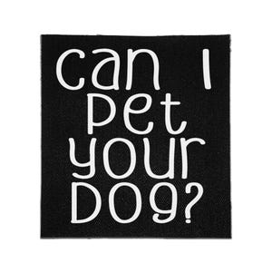 Może przedstawiać: Kwadratowa czarna naszywka z tkaniny z białym napisem "can I pet your DOG?" wydrukowanym swobodną, zaokrągloną czcionką bezszeryfową. Materiał ma widoczną tkaną fakturę, a napis jest wyśrodkowany w czterech liniach na ciemnym tle.