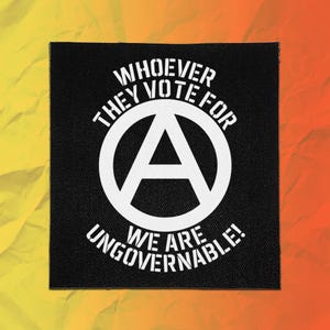 May include: A square black fabric patch featuring a white circular anarchy symbol in the centre. The text "WHOEVER THEY VOTE FOR" is printed in white above the symbol, and "WE ARE UNGOVERNABLE!" is printed in white below the symbol.