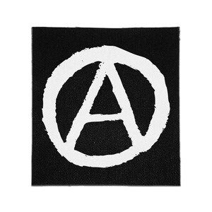 May include: A square fabric patch featuring a black background with a white, hand-drawn style anarchy symbol centered on the surface. The design consists of a capital letter A enclosed within a circle, rendered with a textured, brush-stroke appearance.