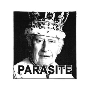 May include: A square black and white fabric patch featuring a high-contrast halftone portrait of a person wearing a crown. The word PARASITE is printed in bold, white, sans-serif capital letters across the lower portion of the design.