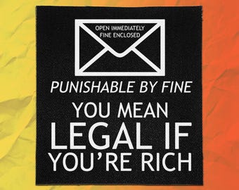 May include: A square black fabric patch featuring a white graphic of an envelope with the text OPEN IMMEDIATELY FINE ENCLOSED. Below the envelope, the text reads PUNISHABLE BY FINE YOU MEAN LEGAL IF YOU'RE RICH in bold white capital letters.