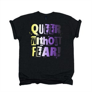 May include: A black short-sleeved t-shirt featuring the text "QUEER WITHOUT FEAR!" printed in a distressed, block-letter style. The lettering displays a gradient colour transition from yellow on the left to purple on the right side.