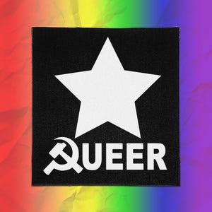Pode incluir: Um emblema quadrado preto com uma grande estrela branca de cinco pontas centralizada no topo. Abaixo da estrela, a palavra QUEER está impressa em letras maiúsculas brancas, com um símbolo branco de foice e martelo substituindo a letra Q.