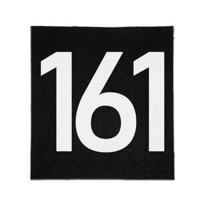 May include: A square fabric patch featuring a black background with the number 161 printed in large, bold, white sans-serif font. The patch has a visible woven texture throughout the black surface and clean, straight edges on all four sides.