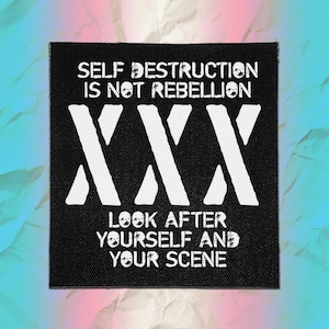 May include: A square black fabric patch featuring white distressed text that reads SELF DESTRUCTION IS NOT REBELLION, followed by three large white X symbols, and the text LOOK AFTER YOURSELF AND YOUR SCENE at the bottom of the design.