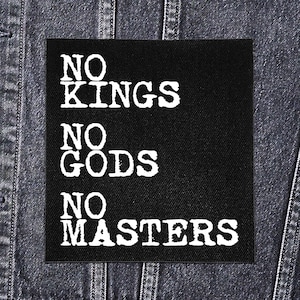 Pode incluir: Patch quadrado preto com o texto branco "NO KINGS NO GODS NO MASTERS". O patch é exibido em uma jaqueta jeans. O texto está em negrito, fonte sem serifa.