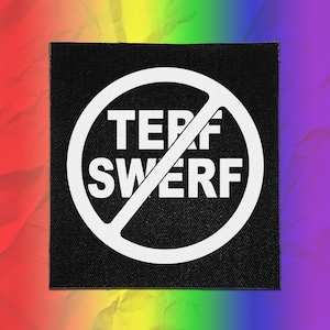 May include: A square black fabric patch featuring a white circular prohibition symbol with a diagonal line crossing through the center. The text TERF SWERF is printed in bold white capital letters inside the circle against the black background.