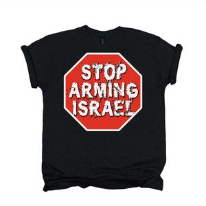 Op de afbeelding: Een zwart t-shirt met korte mouwen en een rood achthoekig stopbord op de borst. Het bord heeft een witte rand en bevat de witte, verweerde, druipende tekst STOP ARMING ISRAEL in dikgedrukte hoofdletters.