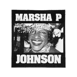 May include: A square black and white fabric patch featuring a high-contrast portrait of Marsha P. Johnson. The text MARSHA P is printed in bold white capital letters above the portrait, and JOHNSON is printed in the same style below the image.