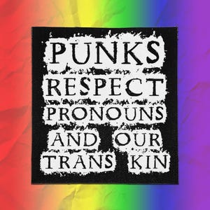 Könnte beinhalten: Ein quadratischer schwarzer Stoffaufnäher mit weißem Text im Used-Look, der lautet: PUNKS RESPECT PRONOUNS AND OUR TRANS KIN. Die Schrift ist in fünf Zeilen angeordnet und weist ein raues, strukturiertes Erscheinungsbild auf dem schwarzen Hintergrund auf.