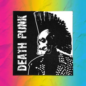 May include: A square black and white fabric patch featuring a graphic of a skull with a large mohawk hairstyle. The skull is shown in profile, wearing a studded jacket. The text DEATH PUNK is printed vertically in a distressed white font on the left.