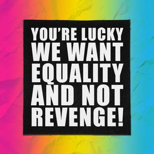 May include: A square black patch with white text that reads, YOU'RE LUCKY WE WANT EQUALITY AND NOT REVENGE! The patch has a visible fabric texture and is set against a vibrant, multi-colored background with a gradient of pink, yellow, and blue.