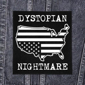 May include: Black patch with white text and a graphic of the United States flag. The text reads "DYSTOPIAN NIGHTMARE" in a bold, sans-serif font. The flag design is a stylized outline of the U.S. map with stars and stripes.