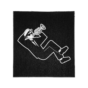 May include: A square black fabric patch featuring a white line art illustration of a figure wearing a hat and sunglasses, reclining while playing a trumpet. The design is rendered in a bold, minimalist style with clean white outlines on a black background.