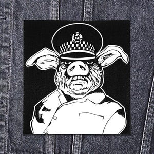 May include: Black and white patch featuring a pig wearing a police hat and uniform. The pig has an angry expression. The patch is square and appears to be sewn onto a denim jacket.