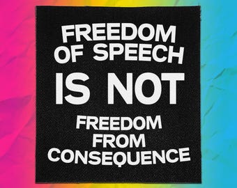 Op de afbeelding: Een vierkante zwarte stoffen patch met de witte tekst FREEDOM OF SPEECH IS NOT FREEDOM FROM CONSEQUENCE in een vet, schreefloos lettertype. De patch heeft een zichtbare geweven textuur en is gecentreerd tegen een levendige, veelkleurige achtergrond.