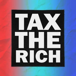 May include: A square black fabric patch featuring the bold white text TAX THE RICH in a sans-serif font. The patch has a visible woven texture and is centered against a background that transitions from red on the left to blue on the right.