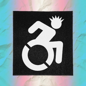May include: A square black fabric patch featuring a white graphic of a stylised figure in a wheelchair. The figure has a spiky, punk-inspired hairstyle. The design is printed in a bold, high-contrast white ink against the solid black background.