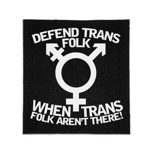 May include: A square black fabric patch featuring a white printed transgender symbol in the centre. The text "DEFEND TRANS FOLK" is arched above the symbol, and the text "WHEN TRANS FOLK AREN'T THERE!" is printed in a straight line below it.