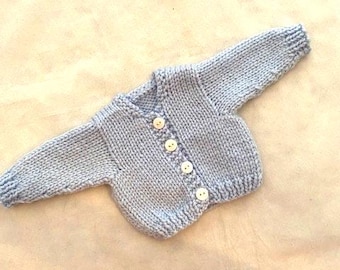 Light blue handknit cardigan sweater that fits 18 inch dolls