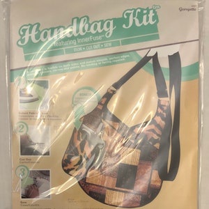 May include: Handbag kit featuring InnerFuse, a fusible fabric that makes smooth, perfect edges. The kit includes instructions for selecting fabric, cutting out the pattern, and sewing. The kit is for a handbag with a geometric pattern in brown, black, and white.