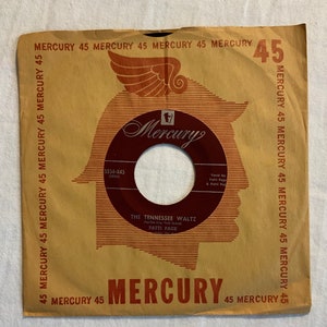 Peut inclure: Une pochette de disque vinyle 45 tours en papier brun avec un logo Mercury Records rouge et blanc. La pochette présente un motif d'ailes rouge et blanc et le texte "The Tennessee Waltz" de Patti Page.