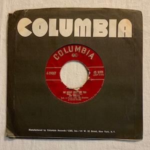 Pode incluir: Um disco de vinil vermelho com um rótulo branco. O rótulo tem o texto "COLUMBIA" em um círculo branco com uma borda preta. O texto "4-39067" é impresso em branco no lado esquerdo do rótulo. O texto "MY HEART CRIES FOR YOU" é impresso em branco no rótulo. O texto "GUY MITCHELL" é impresso em branco no rótulo. O texto "Orch. & Chorus under the direction of MITCH MILLER" é impresso em branco no rótulo. O texto "45 RPM (ZSP 4137)" é impresso em branco no lado direito do rótulo.