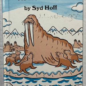 Puede incluir: Un libro infantil titulado "Walpole" de Syd Hoff. La portada presenta una ilustración de dibujos animados de una morsa con sus crías en un paisaje ártico nevado. El libro forma parte de la serie "An Early I Can Read Book".