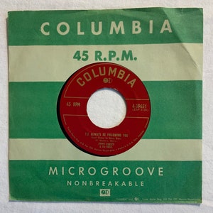 Puede incluir: Una etiqueta de disco de vinilo rojo y blanco de 45 RPM para la canción "I'll Always Be Following You" de Jimmy Dorsey y su orquesta. La etiqueta es de Columbia Records y presenta el título de la canción, el artista y el número de disco 4-39651 (ZSP-9126).