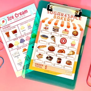 May include: Two colorful menu clipboards, one for an ice cream shop and the other for a bakery. The ice cream menu has options for flavors and toppings. The bakery menu features illustrations of various baked goods, with the text "Sugar & Spice Bakery".