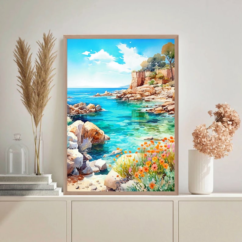 May include: A watercolor painting of a seascape with a rocky coastline, turquoise water, and a small cove. The painting features a bright blue sky with fluffy white clouds and a lush green hillside with orange flowers in the foreground.