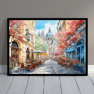 May include: A watercolor painting of a street scene in a European city. The street is lined with buildings and trees, and there are people sitting at tables outside a cafe. The buildings are painted in shades of yellow and brown, and the trees are green and red. The sky is blue and there are clouds in the sky.