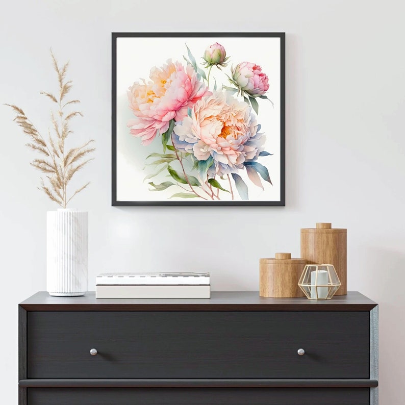 Pode incluir: Uma pintura de aquarela emoldurada de pe&ocirc;nias rosa e brancas com folhas verdes. A pintura est&aacute; em uma moldura preta e est&aacute; pendurada em uma parede branca.