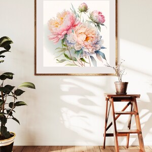 Pode incluir: Uma pintura de aquarela emoldurada de pe&ocirc;nias rosa e brancas com folhas verdes. A pintura est&aacute; em uma moldura de madeira clara e est&aacute; pendurada em uma parede branca.