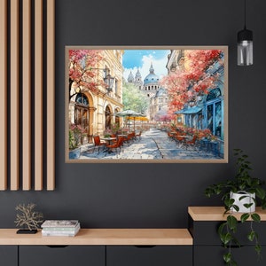 May include: A watercolor painting of a Parisian street scene with a cafe and a church in the background. The cafe has red tables and chairs and is surrounded by trees with pink and red flowers.
