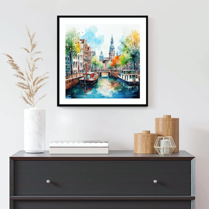 May include: Watercolor painting of a canal in Amsterdam, Netherlands. The painting features a narrow canal with buildings lining the sides, a bridge, and two boats. The buildings are painted in a variety of colors, including red, orange, yellow, and green. The canal is painted in shades of blue and green. The sky is painted in shades of blue and white.