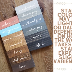 May include: Wood stain colour samples in various shades of red, blue, brown, and grey. The samples are labelled with the names of the colours, such as "Sedona Red", "Vintage Aqua", "Special Walnut", "Provincial", "Honey", "Dark Walnut", "Kona", "Sunbleached", "Classic Grey", "Weathered Grey", "Carbon Grey", "Ebony", and "Black". The text "STAIN COLOURS MAY BE LIGHTER OR DARKER DEPENDING ON HOW THE WOOD TAKES THE STAIN. EXPECT SLIGHT VARIANCES" is written in a decorative font.