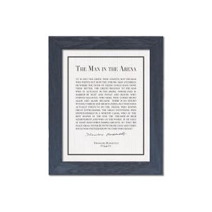K&ouml;nnte beinhalten: Gerahmter Druck mit dunkelblauem Rahmen, der den Text "The Man in the Arena" von Theodore Roosevelt zeigt. Der Druck hat einen wei&szlig;en Hintergrund mit schwarzem Text. Das Zitat ist zentriert und enth&auml;lt Roosevelts Unterschrift.