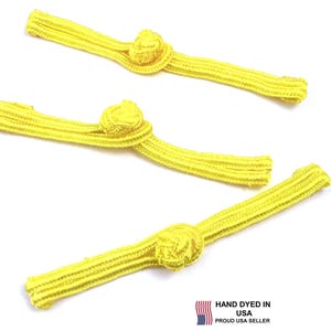 May include: Three bright yellow frog closures, each featuring a central decorative knot and two parallel corded extensions. The design includes a small flag icon and the text HAND DYED IN USA PROUD USA SELLER printed in the bottom right corner.