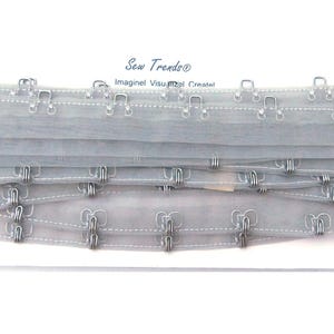 May include: Gray elastic bra strap with metal hooks and eyes. Sew Trendo Imagined Visualized Created.